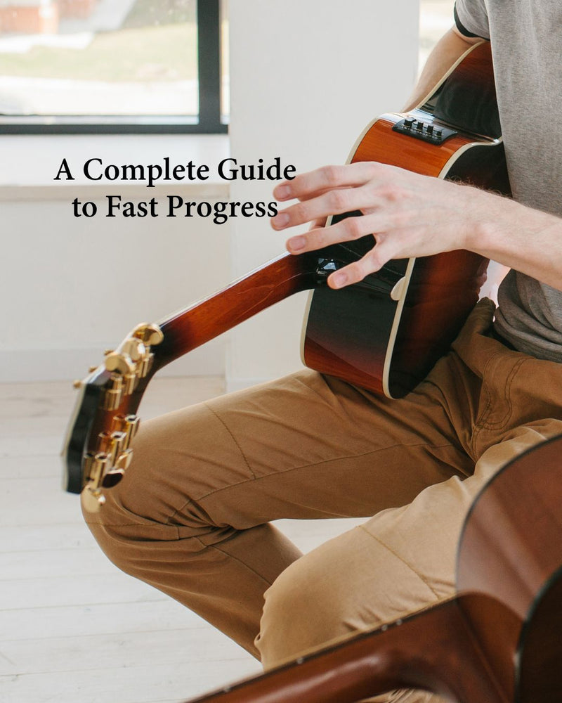 Home shot of man playing acoustic guitar, Text overlay reads "A Complete Guide to Fast Progress"