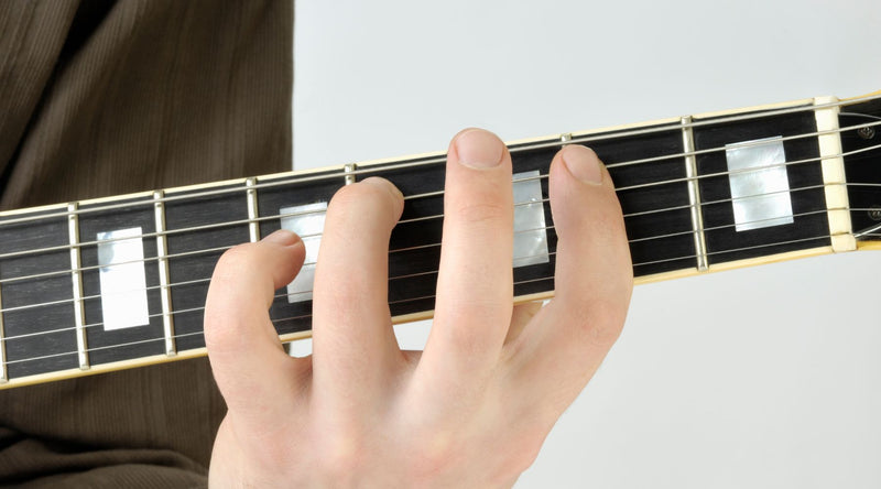 Fingers are on the electric guitar fretboard