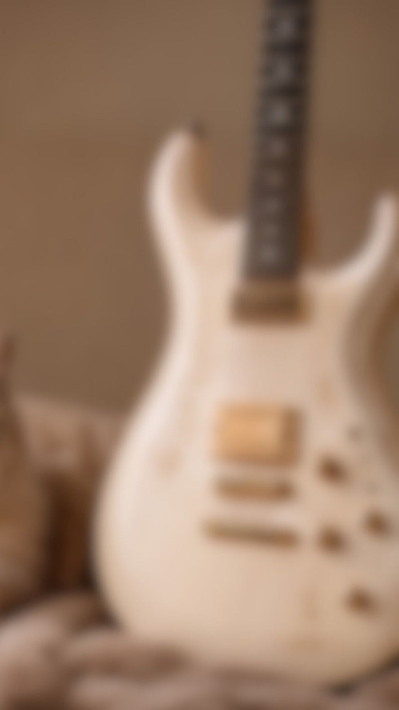 Blurred image of a guitar with a neutral background