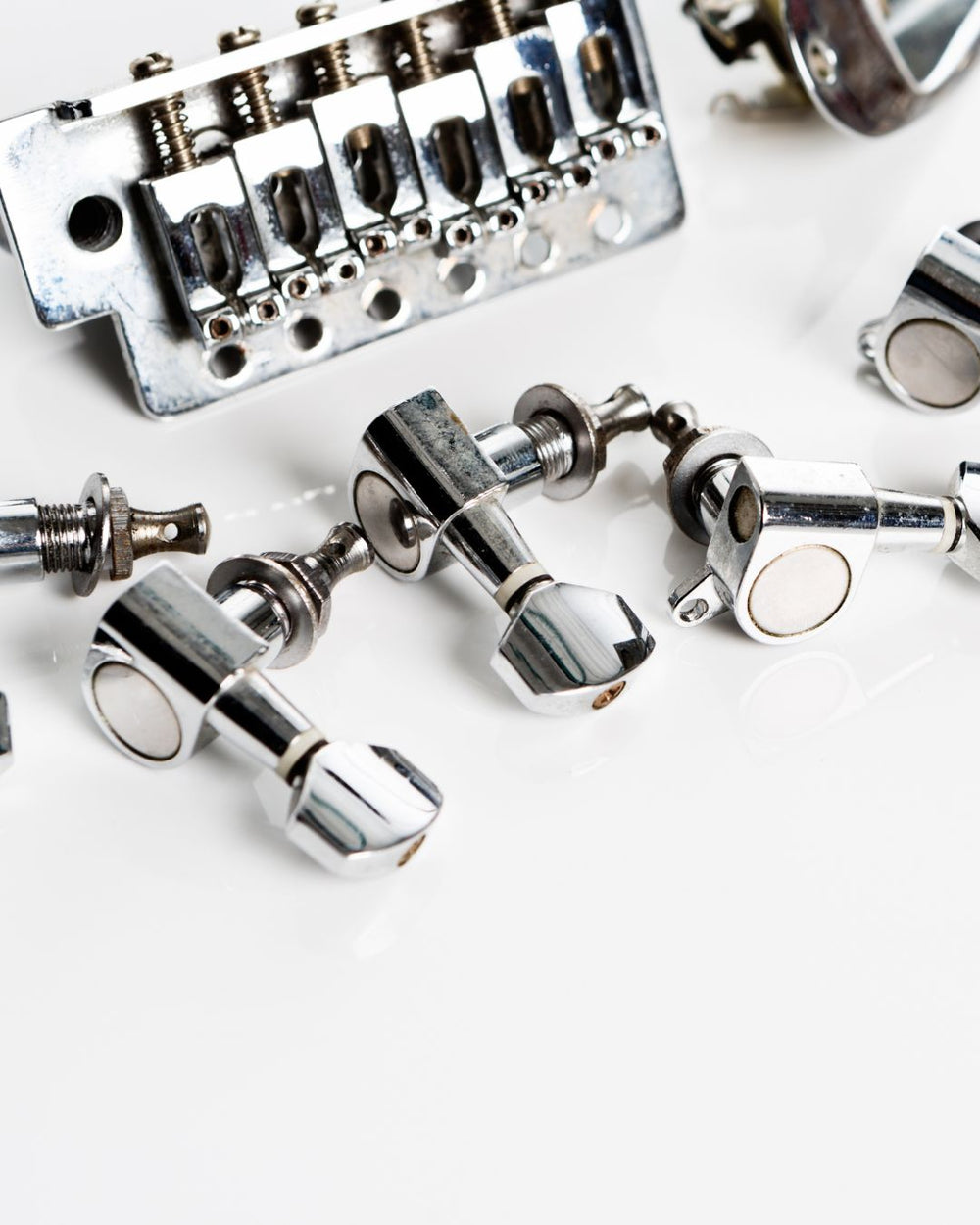 Close-up of guitar tuners and bridge on a white background
