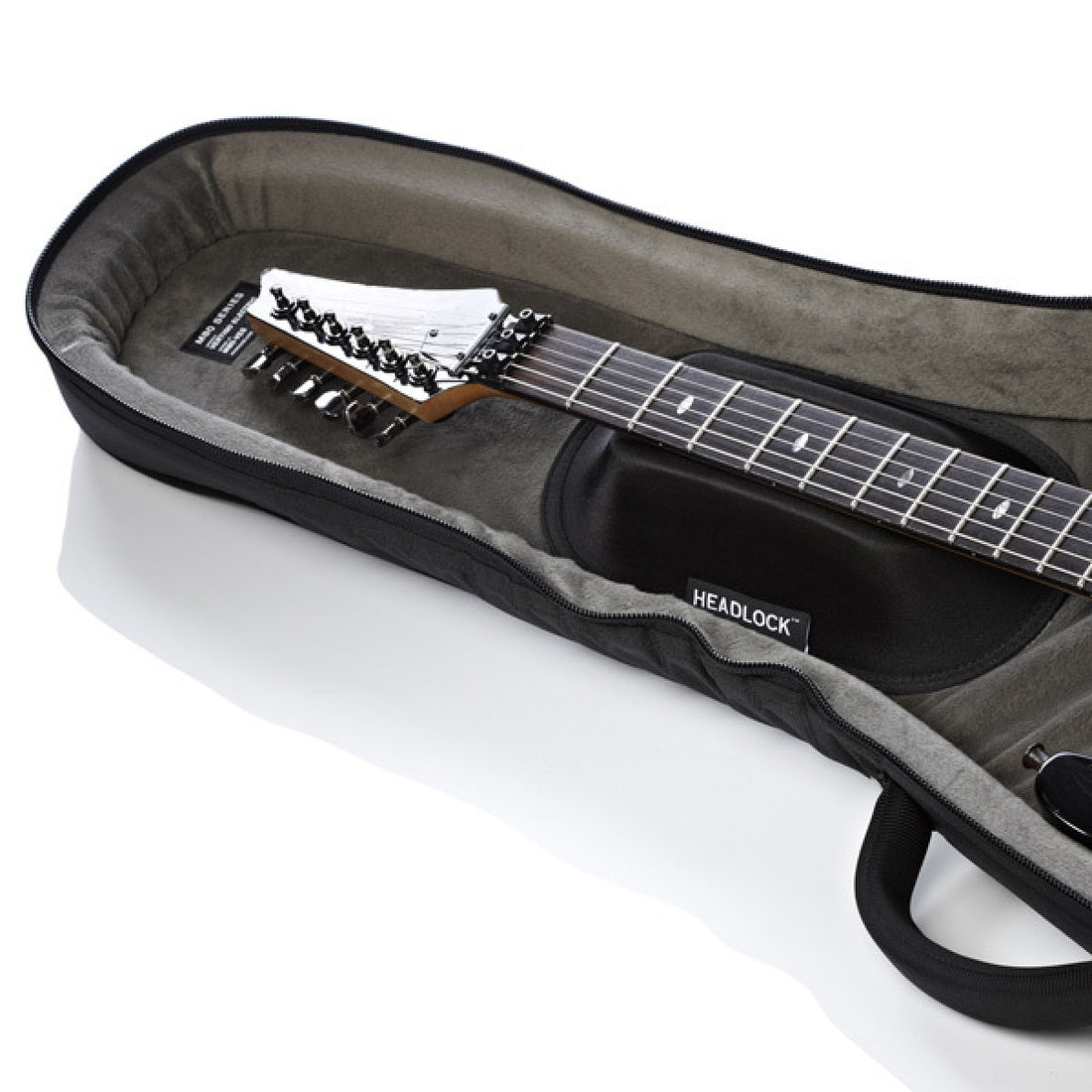 A guitar inside an open padded gig bag on a clean white background. The gig bag is black with a gray interior and a visible HEADLOCK brand label.